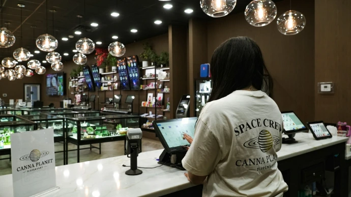 Customer uses tablet at counter in dispensary.